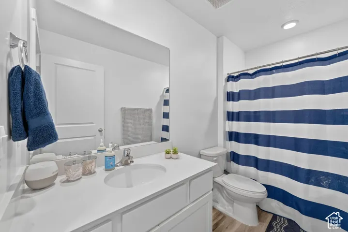 White vanity with an integrated sink, polished chrome faucet, and expansive wall mirror