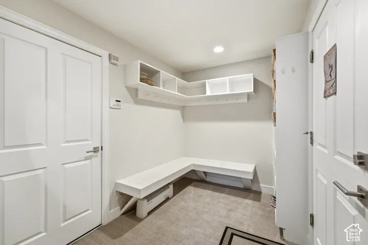 Built-in shelving with integrated hooks, L-shaped bench seating, and recessed lighting