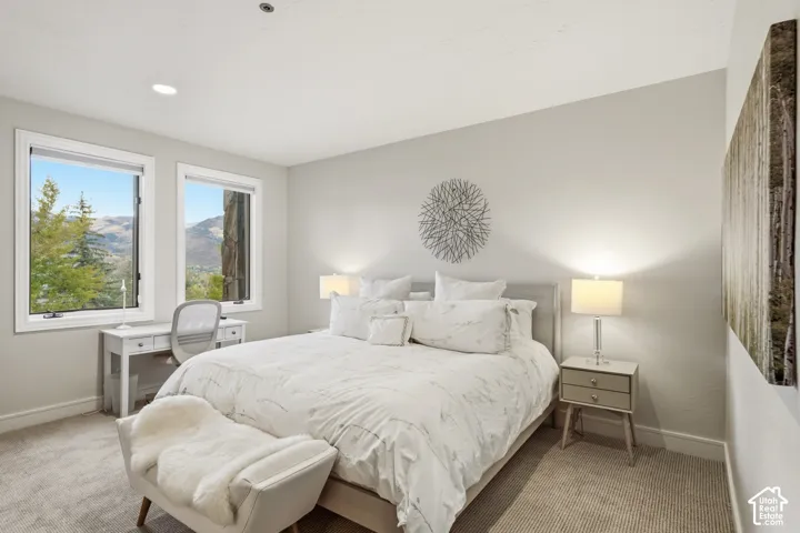 Recessed lighting, light-toned walls, and carpeted flooring