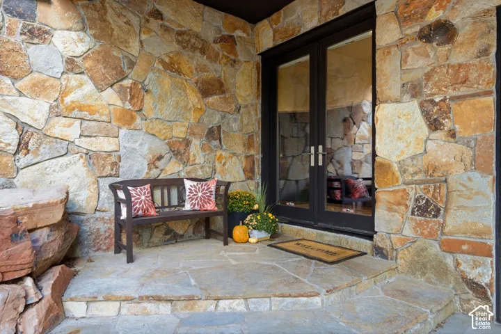 Stone-clad exterior featuring a double-door entry with dark frames and integrated handles