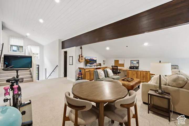 Carpeted open-concept bonus room featuring a vaulted plank ceiling, recessed lighting, and a dark wood-finish beam