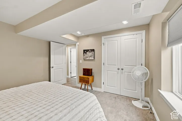 Neutral-toned interior featuring recessed lighting, carpeted flooring, double-panel closet doors, and a window with a built-in sill
