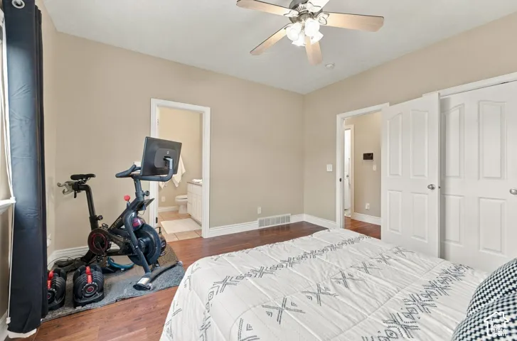 Room featuring wood-finish flooring, a ceiling fan with light kit, and double-panel doors