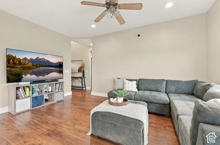Neutral wall finishes, wood-finish flooring, recessed lighting, and a multi-blade ceiling fan