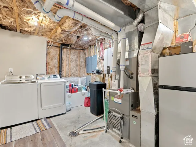Utility area featuring a furnace, water heater, electrical panel, and exposed ceiling joists with fiberglass insulation