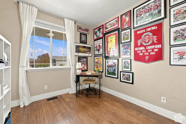 Room featuring wood-finish flooring and a single-pane window with a horizontal muntin