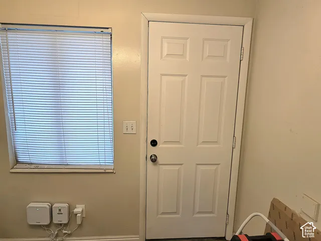 Six-panel white entry door with metallic hardware and window featuring horizontal blinds