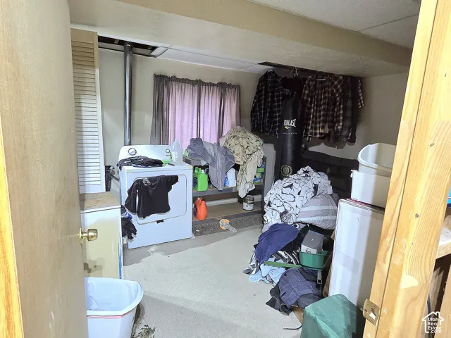 Utility area featuring louvered door closet storage and drop-ceiling panels