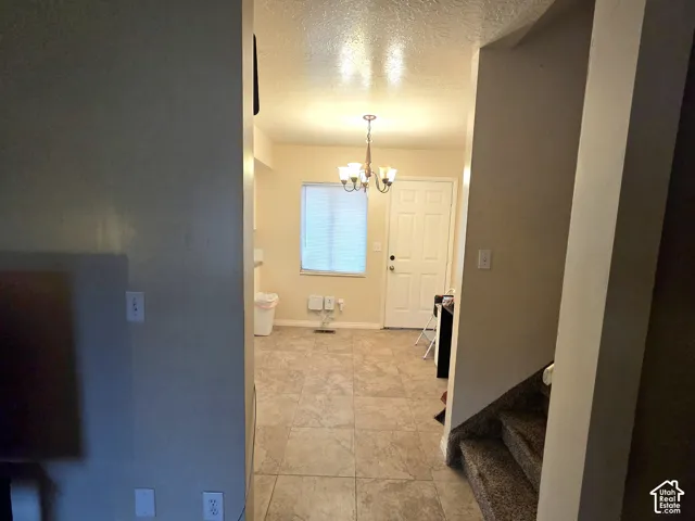 Tile flooring, multi-arm chandelier, and a panelled exterior door