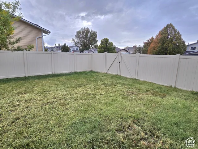Backyard featuring a privacy fence, gated entry, and lawn