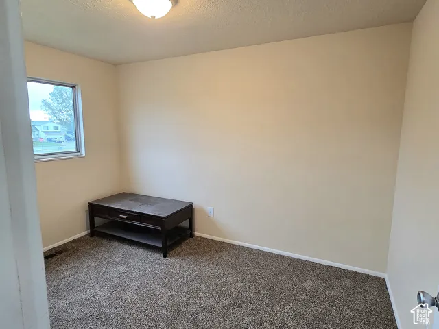 Room featuring neutral wall tones, textile flooring, and a flush-mount ceiling light fixture