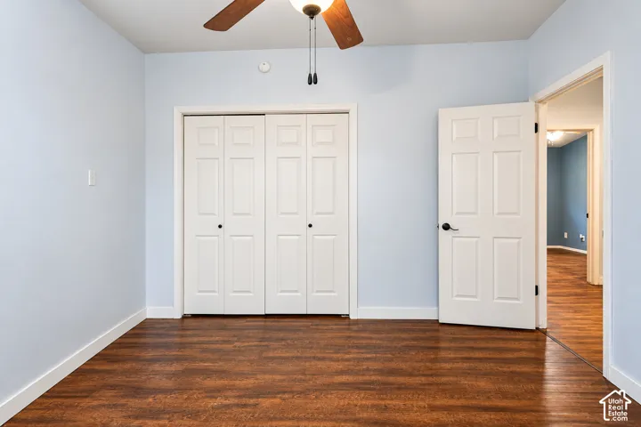 Wood-finish flooring, bi-fold closet doors, and ceiling fan with integrated lighting
