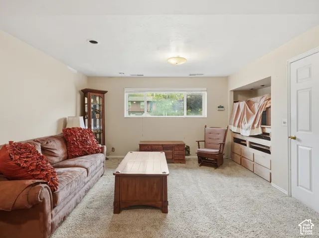 Room featuring neutral wall tones, carpeted flooring, a wide window with a top-down blind, a recessed wall nook, and a six-panel interior door