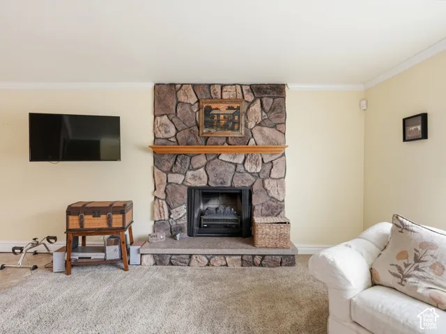 Full-height stone fireplace featuring a wood mantel and a raised stone hearth