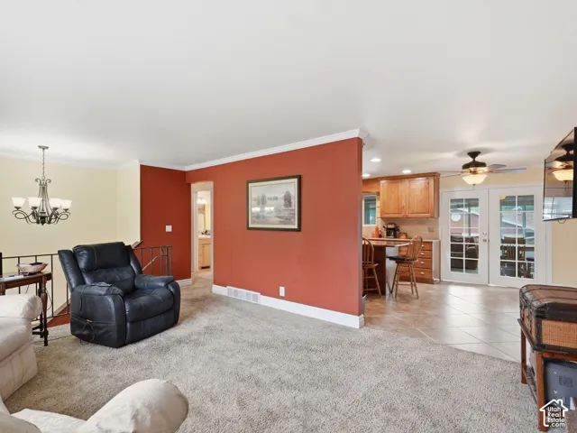 Open-concept interior featuring wood-finish cabinetry, ceramic tile flooring, recessed lighting, and a multi-arm chandelier