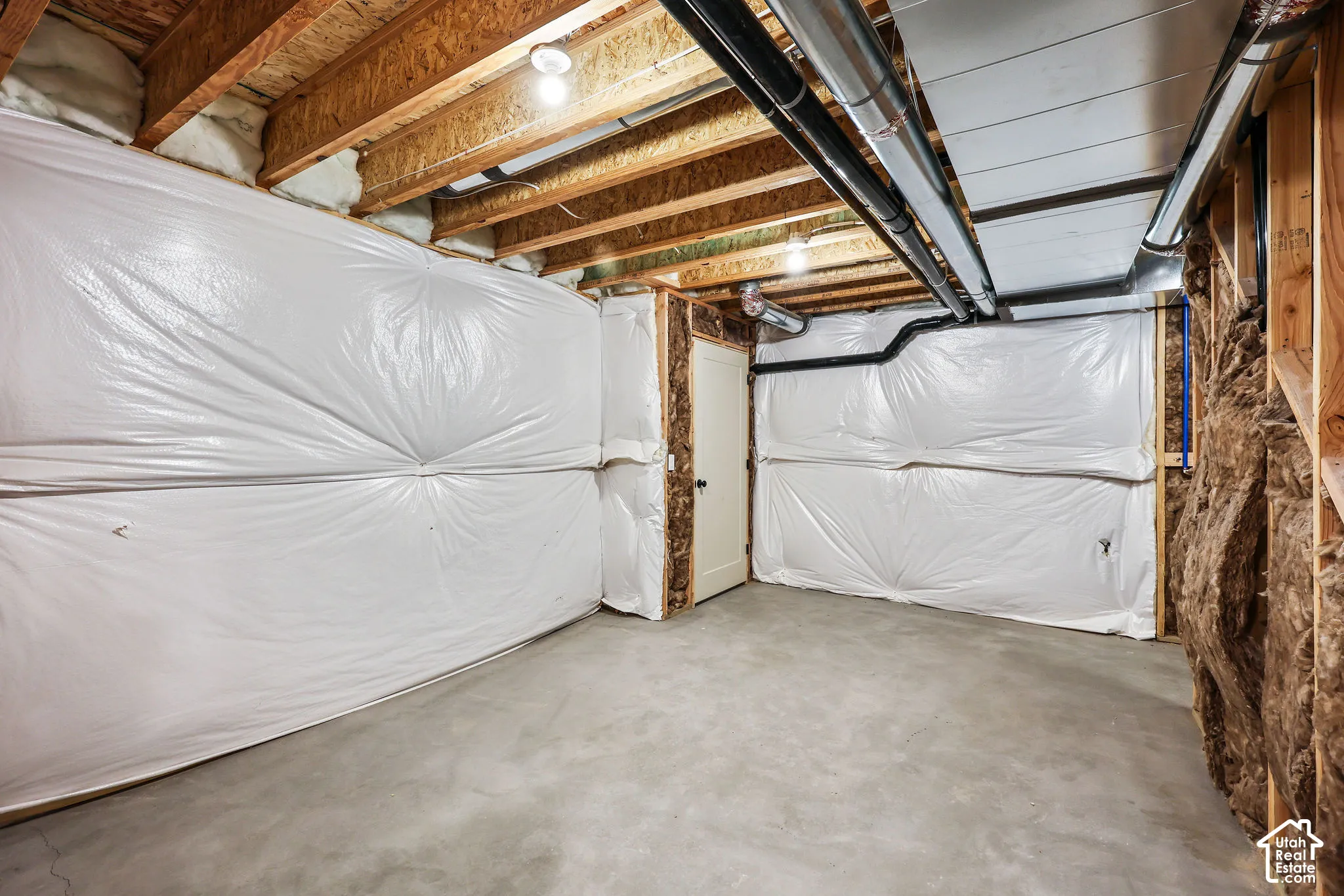 Unfinished basement with concrete flooring and exposed ceiling joists