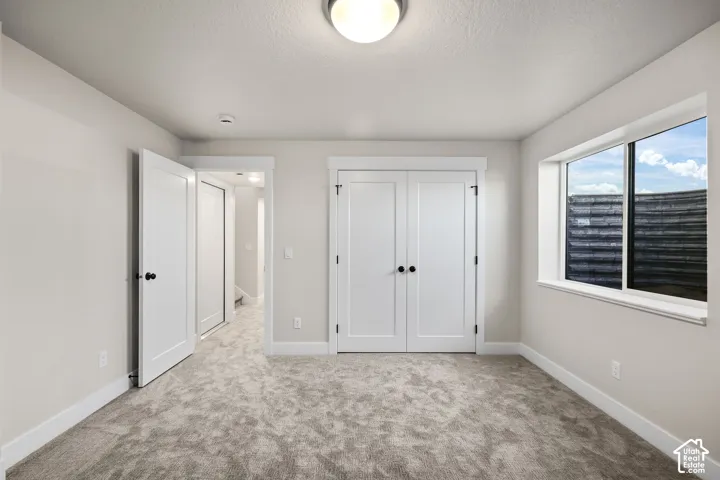 Neutral-toned room featuring soft carpet flooring and white trim
