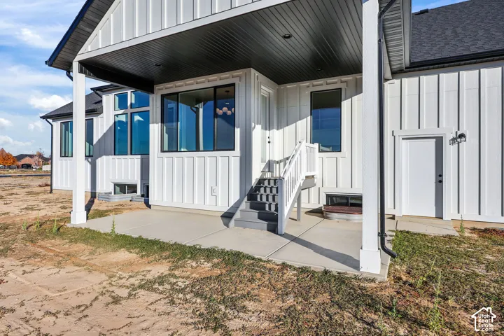 Covered concrete patio with white board and batten siding