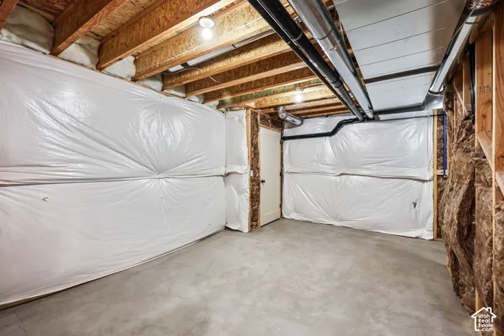 Unfinished basement with concrete flooring and exposed ceiling joists