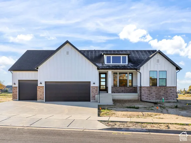 **Home is TO BE BUILT! Pictures represent a previously built and purchased home. Contemporary farmhouse exterior featuring white board and batten siding, brick accents, a dark shingle roof, a two-car garage with dark doors, and an inviting front entrance