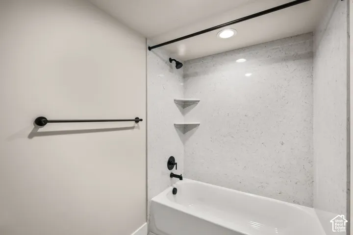 Bathtub with matte black fixtures and a shower curtain rod