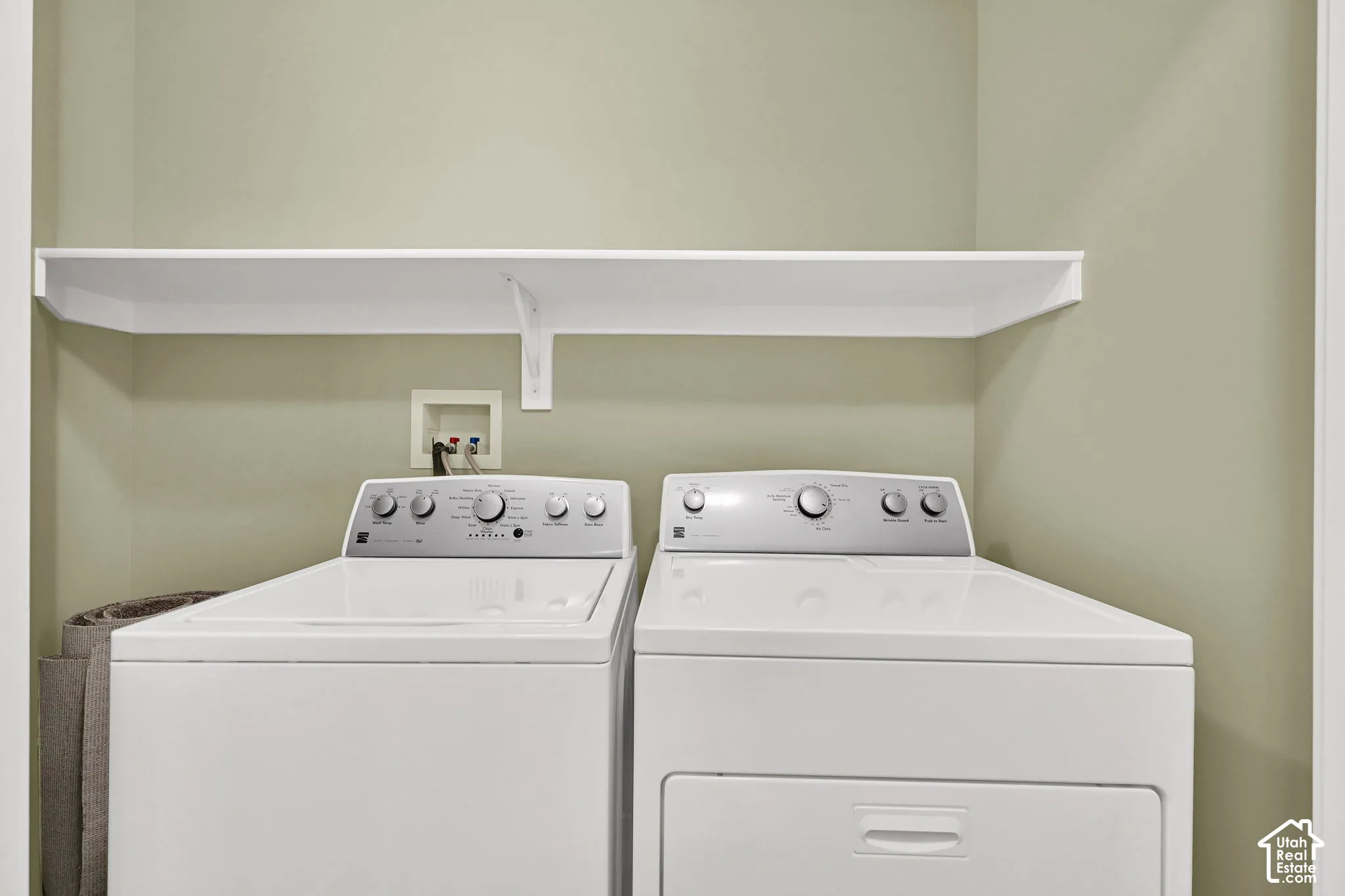 Dedicated laundry area featuring a white built-in wall shelf and utility hookups