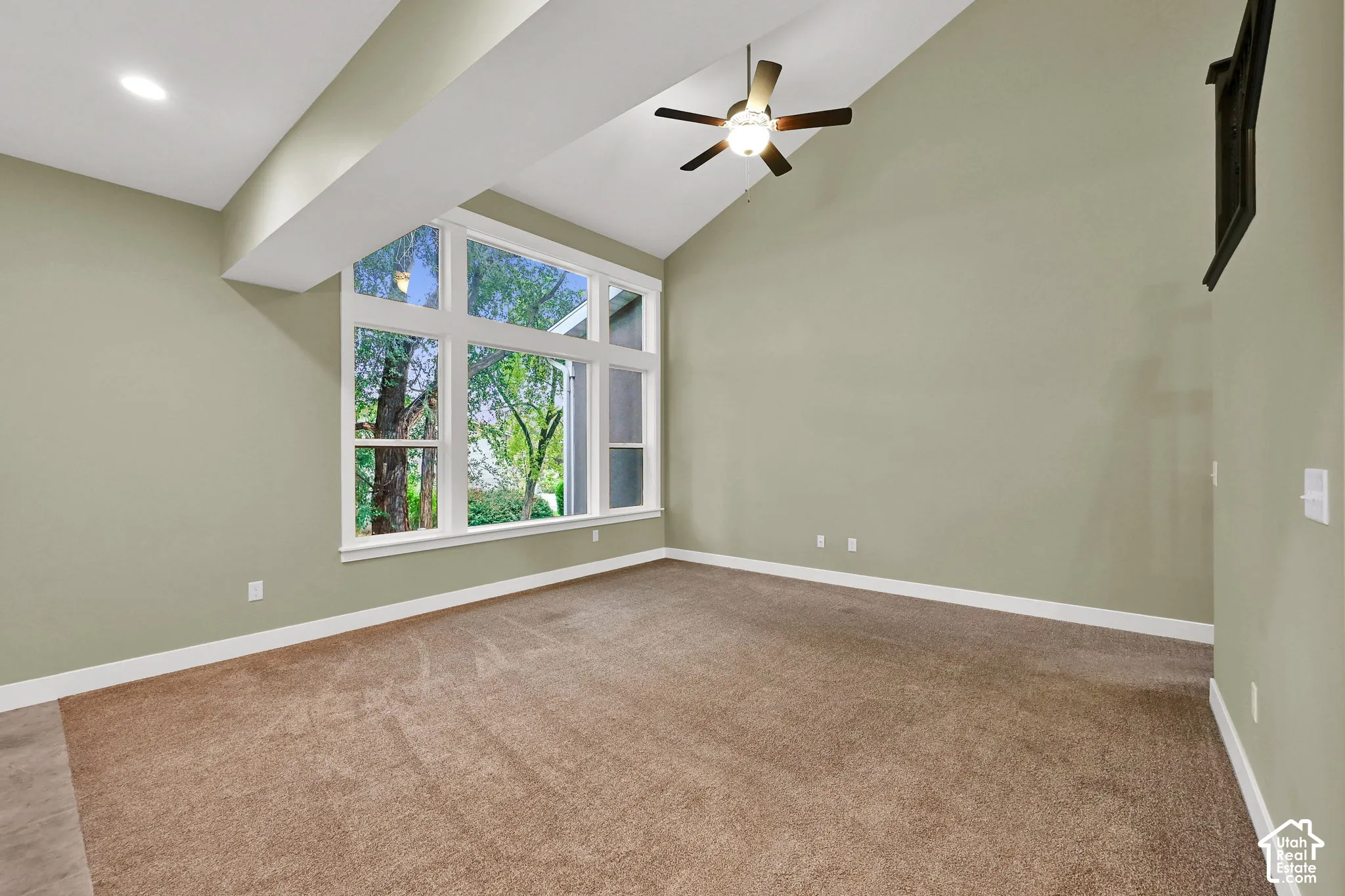 Vaulted ceilings featuring a multi-pane window configuration, recessed lighting, and a centrally mounted ceiling fan