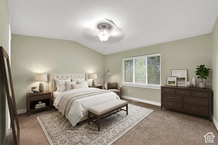 Room featuring a vaulted ceiling, neutral wall tones, plush wall-to-wall carpeting, and a multi-blade ceiling fan with integrated lighting