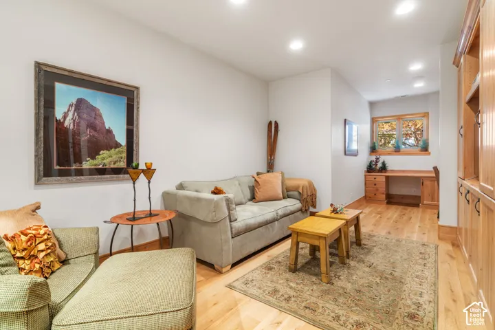 Wood-finish flooring, custom built-in cabinetry, recessed lighting, and a built-in wooden desk area