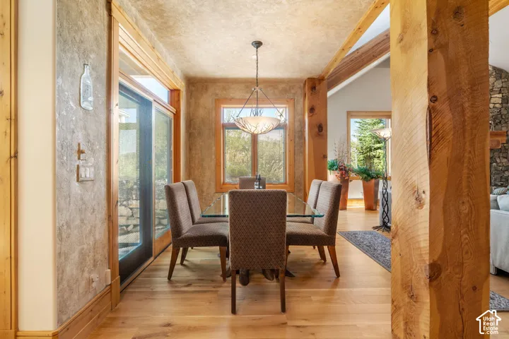 Textured wall finish, exposed timber post, wood-finish flooring, sliding glass door, and pendant lighting