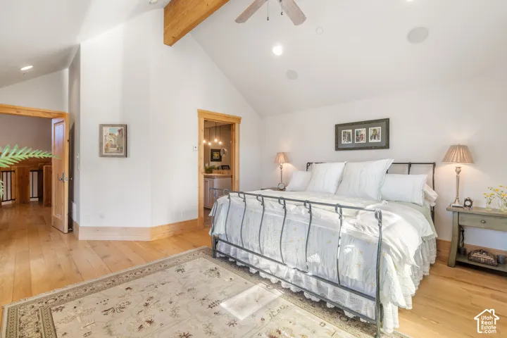 Vaulted ceilings with exposed timber beams, recessed lighting, and wood-finish flooring