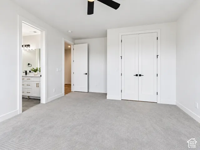 Bedroom 3 not staged. Jack-jill bathroom. Bedroom has neutral-toned carpeting, double-door closet, and ceiling fan fixture