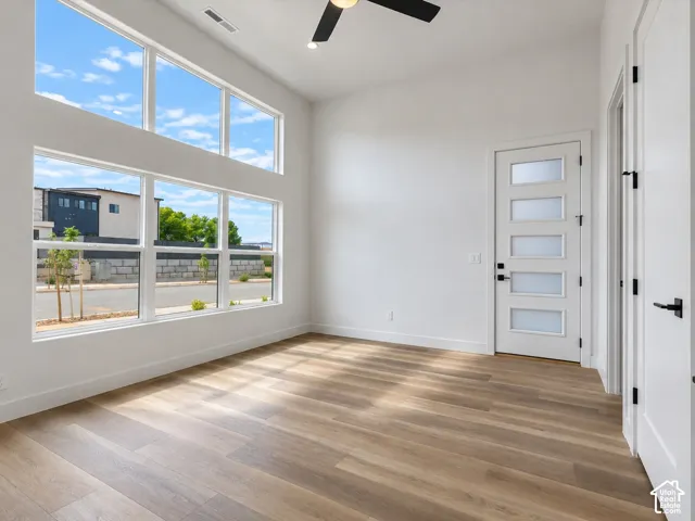 Casita/Office not staged, featuring expansive floor-to-ceiling windows, wood-finish flooring, and a multi-panel frosted exterior glass door.