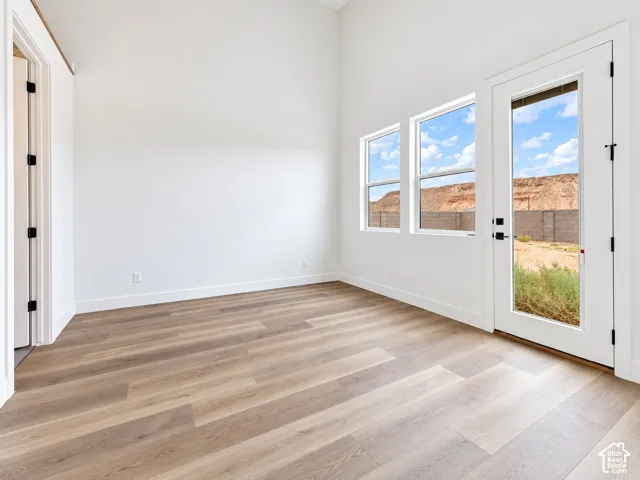 Guest Suite w/own bathroom and back entrance featuring wood-finish flooring, multi-pane windows, and a glass-paneled exterior door with mountain scenery.