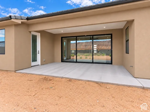 Covered concrete patio featuring recessed lighting, multi-panel sliding glass doors, and a secondary glass-panel entry door