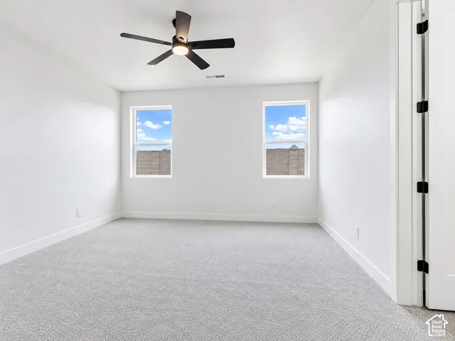 Bedroom 3 not staged. Jack-jill bathroom. Bedroom has neutral-toned carpeting, double-door closet, and ceiling fan fixture