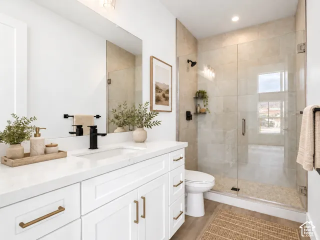 Casita bathroom featuring white cabinetry, solid-surface countertop, and a walk-in shower with floor-to-ceiling tile surround and glass enclosure. Home is virtually staged.