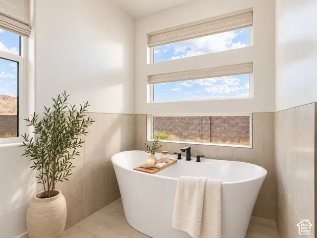 Primary Bathroom with freestanding soaking tub featuring, horizontal window configuration, and neutral-tone tile surround. Home is virtually staged.
