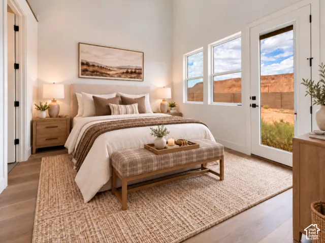 Guest Suite w/ own bathroom and back entrance featuring wood-finish flooring, multi-pane windows, and a glass-paneled exterior door with mountain scenery. Home is virtually staged.