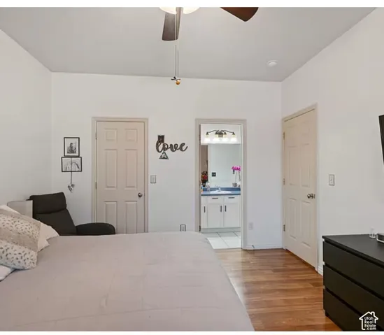 Wood-finish flooring, six-panel interior doors, and a ceiling fan
