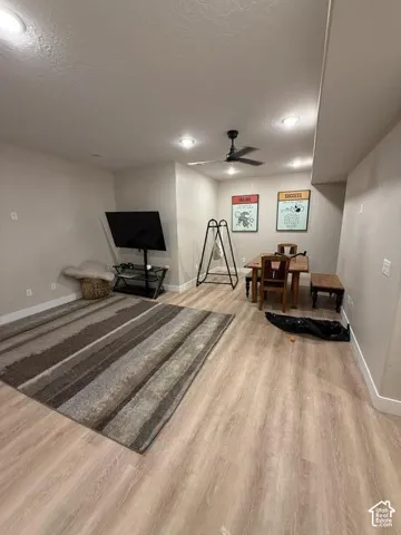 Neutral-toned interior space featuring wood-finish flooring, recessed lighting, and a black ceiling fan