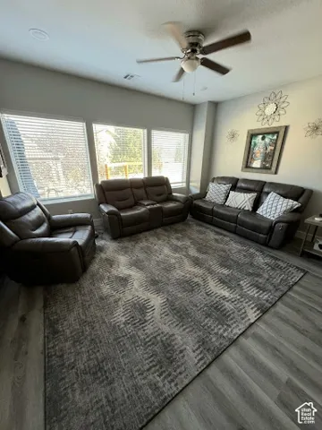 Living area featuring wood-finish flooring, recessed lighting, a ceiling fan, and large windows with horizontal blinds
