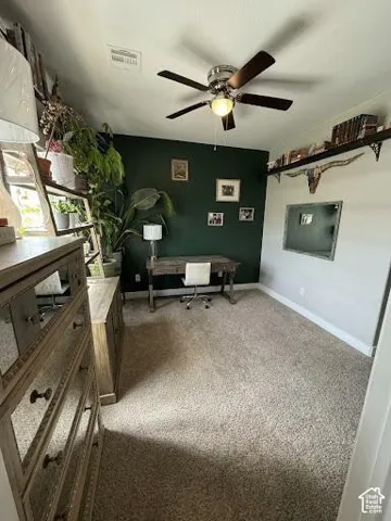 Room featuring a ceiling fan with integrated lighting, neutral carpeting, and a custom wall-mounted shelving unit