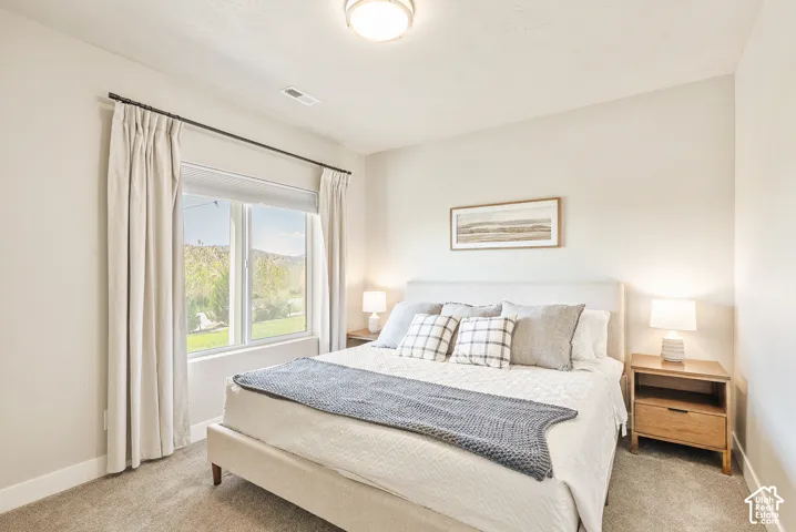 Neutral-toned interior space featuring neutral wall-to-wall carpeting, a large picture window, and a flush-mount ceiling light fixture