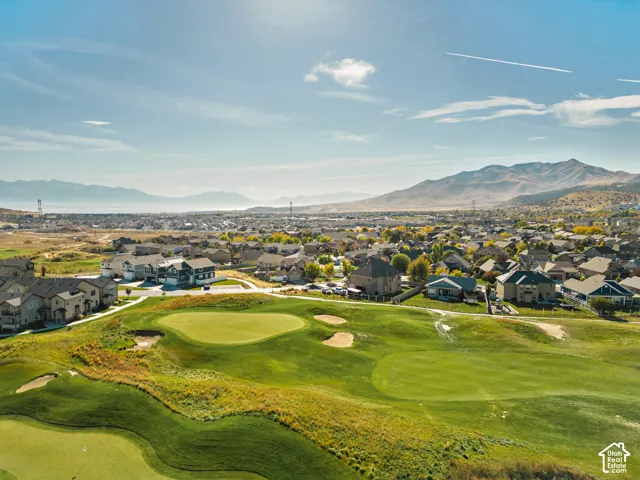 Aerial perspective featuring proximity to a golf course, expansive mountain scenery, and manicured green space