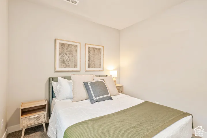 Neutral-toned interior space featuring light-colored wall paint and dark carpeting