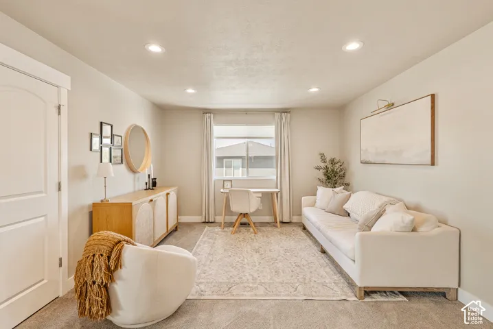 Neutral-toned interior space featuring recessed ceiling lighting, wall-to-wall carpeting, and an arched-panel solid-core interior door