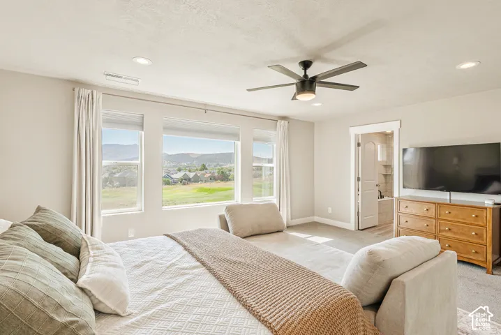 Neutral-toned room featuring large windows with mountain scenery, recessed lighting, and a ceiling fan