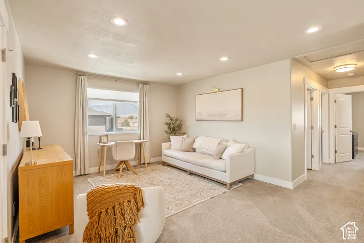 Neutral-toned room featuring recessed lighting, wall-to-wall carpeting, and a large window with mountainous backdrop