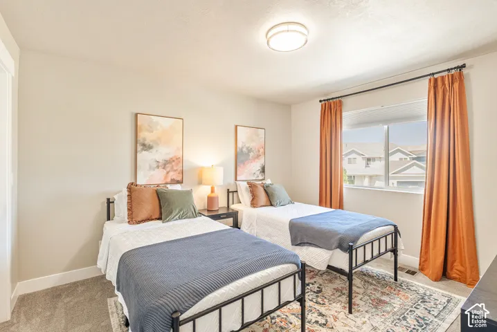 Neutral-toned interior featuring wall-to-wall carpeting, a large sliding window, and a flush-mount overhead light fixture